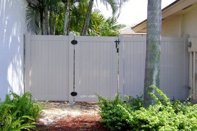 A PVC fence partitioning two homes provides privacy in Palm Beach County, FL